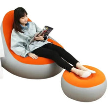 Inflatable orange lounge chair with attached footrest, gray base and curved seat