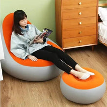 Inflatable orange lounge chair with matching gray footrest ottoman and base