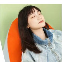 Woman relaxing on a bright inflatable orange lounge chair by Huitich with a peaceful expression