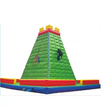Inflatable rock climbing wall with green ramp, red and blue base, yellow top pads