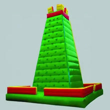 Inflatable climbing wall with bright green ramp, red base blocks, yellow corner pads