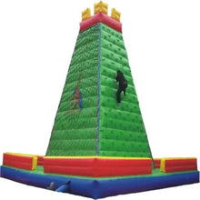 Inflatable climbing wall with green ramp, red support, blue landing mat and climber