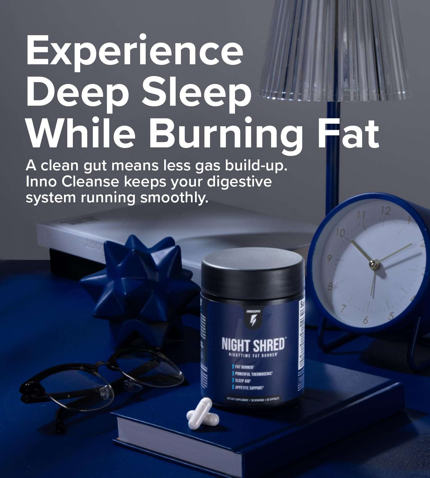 Inno Supps Night Shred review jar and capsules on blue book with clock lamp and glasses showing sleep and fat burn