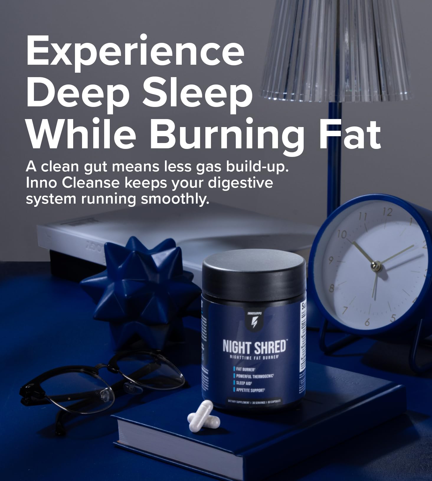 Inno Supps Night Shred review jar and capsules on blue book with clock lamp and glasses showing sleep and fat burn