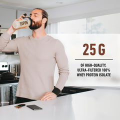 Man drinking Isopure low carb whey protein powder shake in kitchen from branded shaker showing 25g protein
