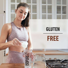Woman in workout clothes pouring Isopure low carb whey protein powder into Isopure shaker bottle in kitchen with gluten free label