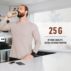 Man drinking from Isopure shaker in kitchen with Isopure whey protein isolate label visible