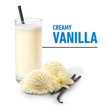 Creamy vanilla protein shake in a glass with vanilla pods and powder scoop