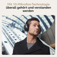 Man wearing Jabra Evolve2 85 wireless headset with 10 microphone technology in modern indoor setting