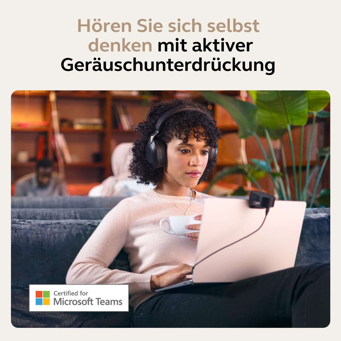 Woman wearing Jabra Evolve2 85 wireless headset working on laptop with active noise cancellation