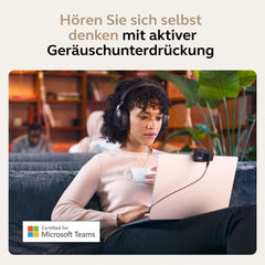 Woman wearing Jabra Evolve2 85 wireless headset working on laptop with active noise cancellation