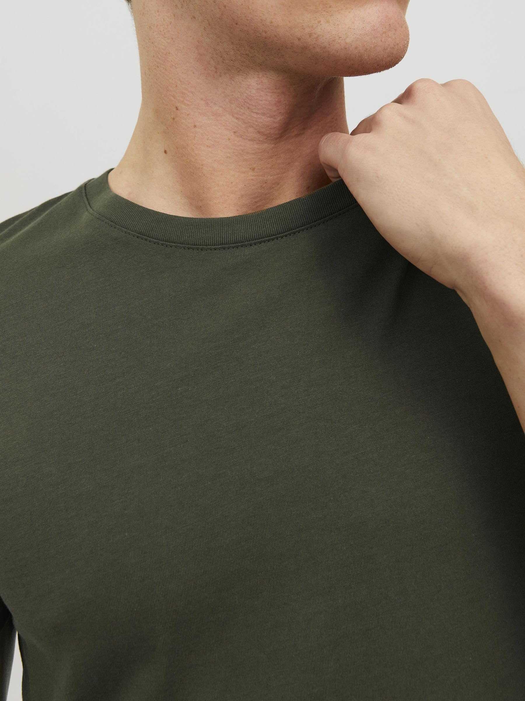 Close-up of a man wearing a green crew neck t-shirt men showing the neckline and shoulder detail