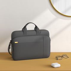 JETech laptop case with shoulder strap in black on desk next to glasses and wireless earbuds
