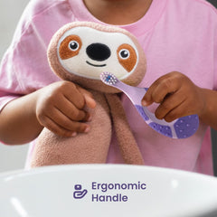 Child holding plush sloth and Jordan purple ergonomic handle soft bristle toothbrush for infants by sink