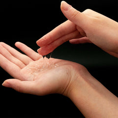 KY Jelly personal lubricant clear gel being dispensed from fingertips into palm showing smooth texture and shine