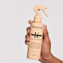 Hand holding a tan curl refresher spray bottle with pump trigger