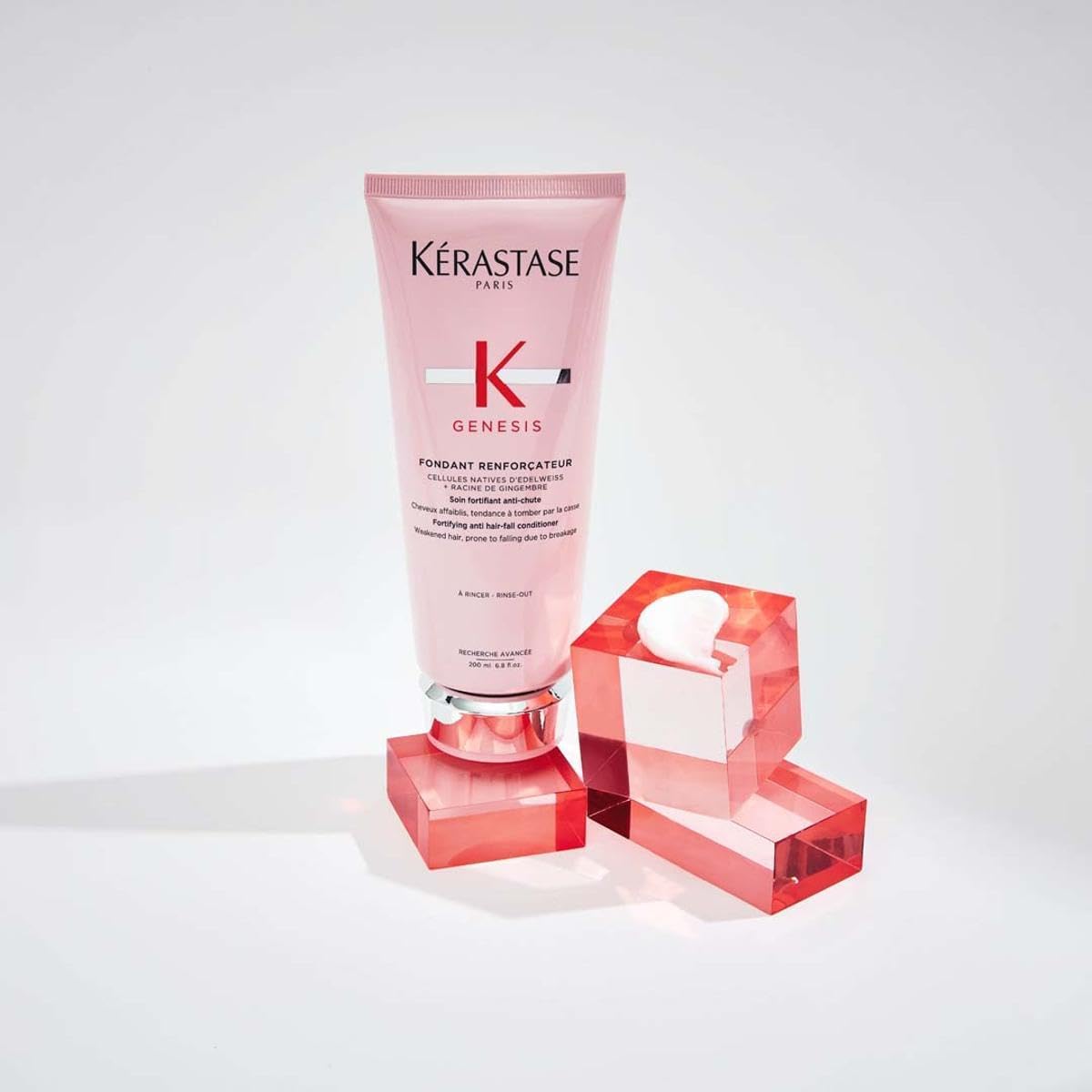 Kérastase Genesis anti-hair fall conditioner in pink tube with stylish geometric blocks