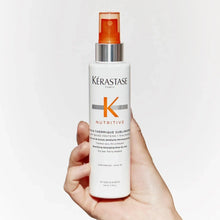 Hand holding heat protectant lotion bottle with orange cap and white label