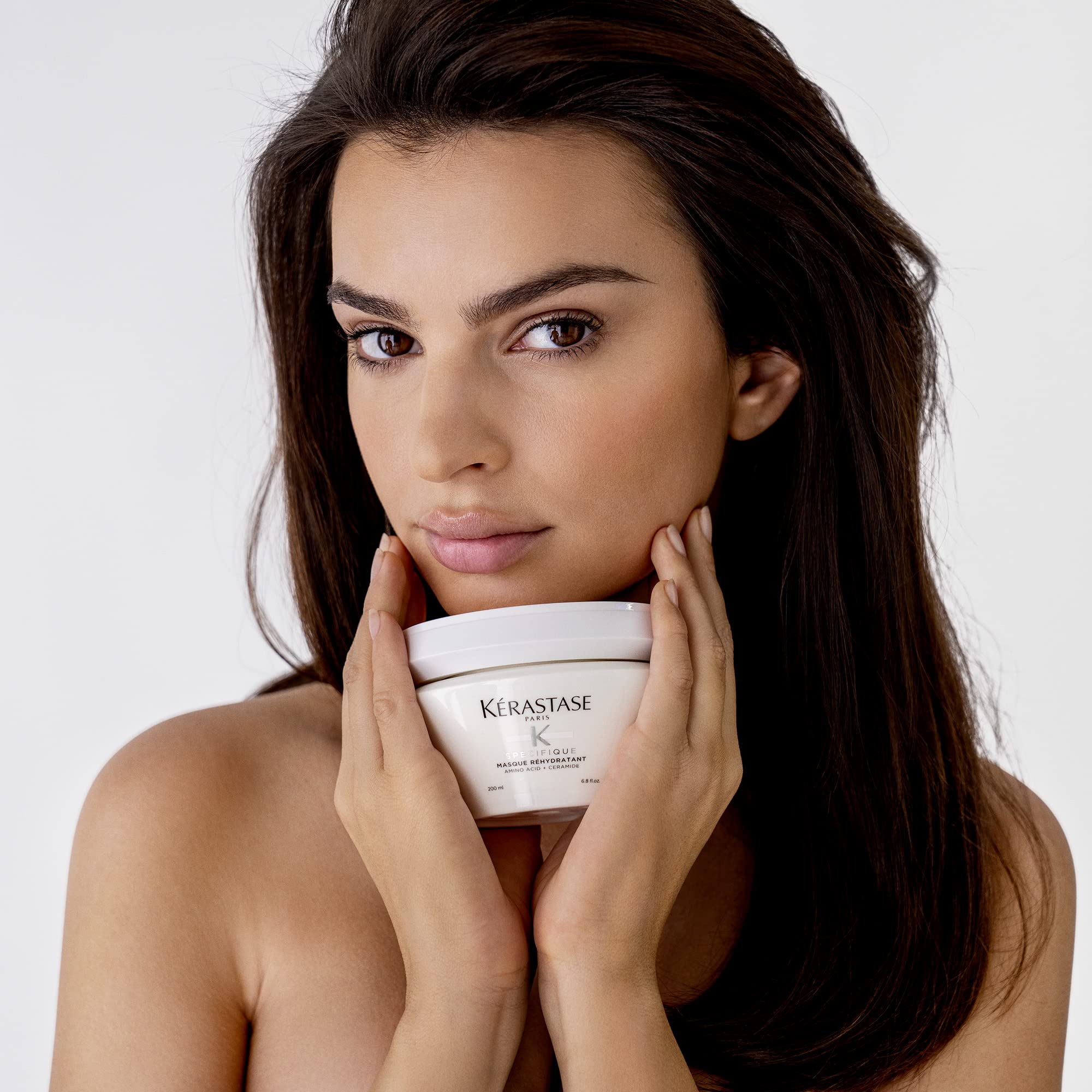 Model holding Kerastase hydrating hair mask for deep nourishment and hydration