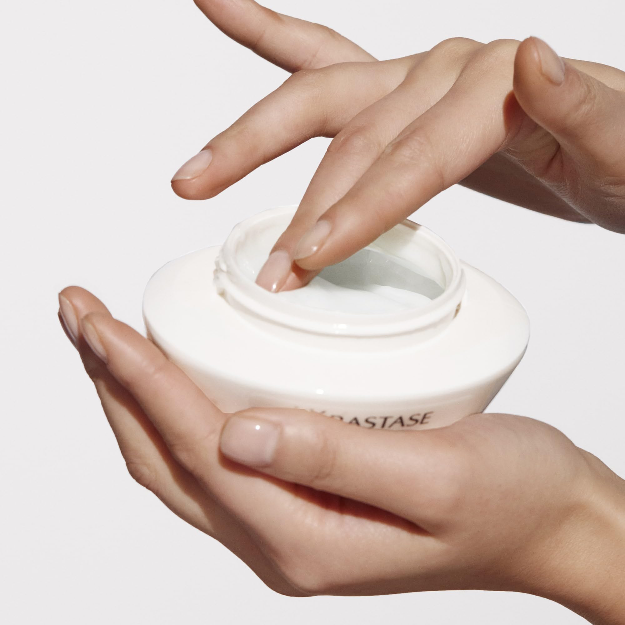Applying Kerastase Nutritive Rich Hair Mask from a white jar for deep hair nourishment