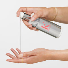 Kerastase Premier Decalcifen shampoo being dispensed into a hand for hair care routine
