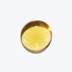 Kerastase Sublime Repair Oil for hair in a circular drop showcasing its rich golden color and smooth texture