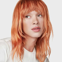 Model with long orange hair styled with natural waves