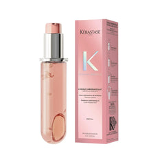 Refillable hair oil bottle with rose-pink liquid and silver pump top