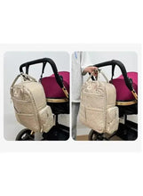 Light beige baby travel bag attached to stroller with carry straps