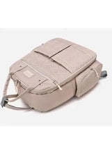 Light beige baby travel bag with padded flap, crossbody strap, and front zips