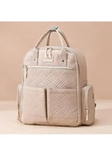 Light beige baby travel bag with front zipper panel and side bottle holder
