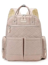 Light beige baby travel bag with quilted panels, top handle, and side pockets