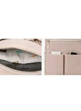 Open light beige baby travel bag revealing organizer pockets and storage sections