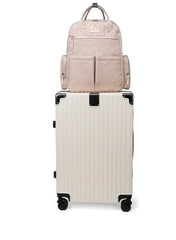 Huitich khaki baby travel bag stacked on a white rolling suitcase for convenient travel