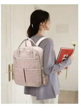 Light beige baby travel bag worn as a backpack with adjustable shoulder straps