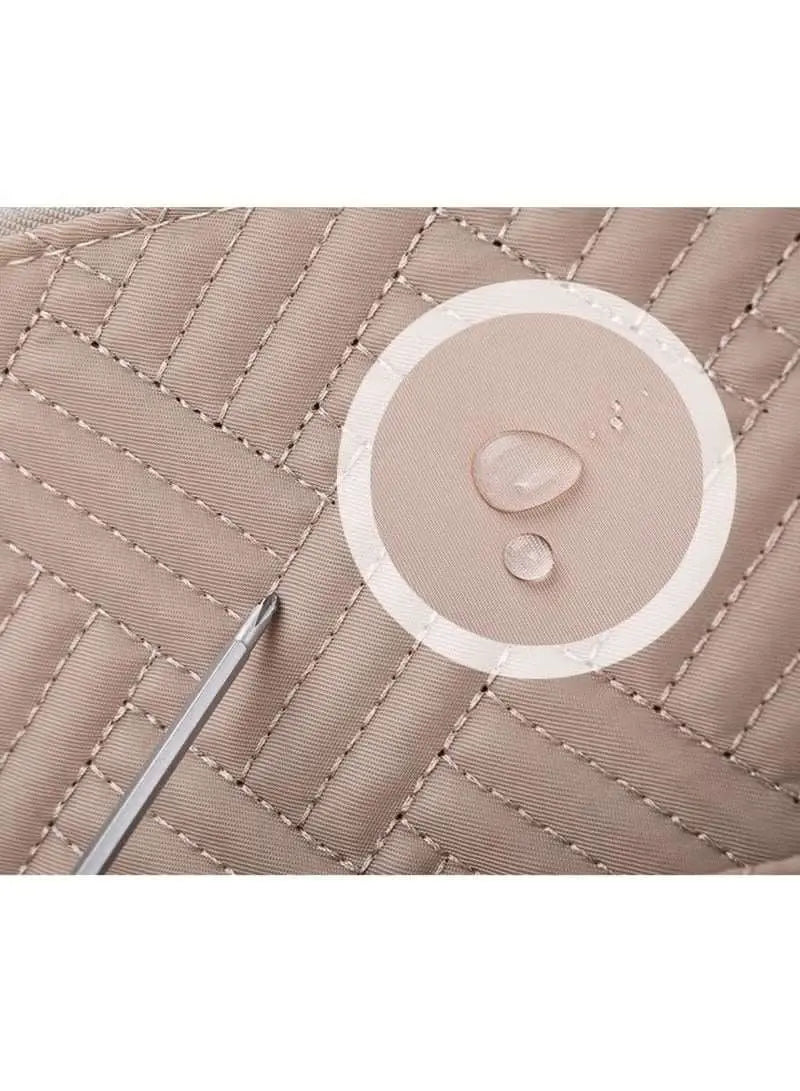 Close-up of water-resistant khaki baby travel bag fabric showing drops of water on quilted surface