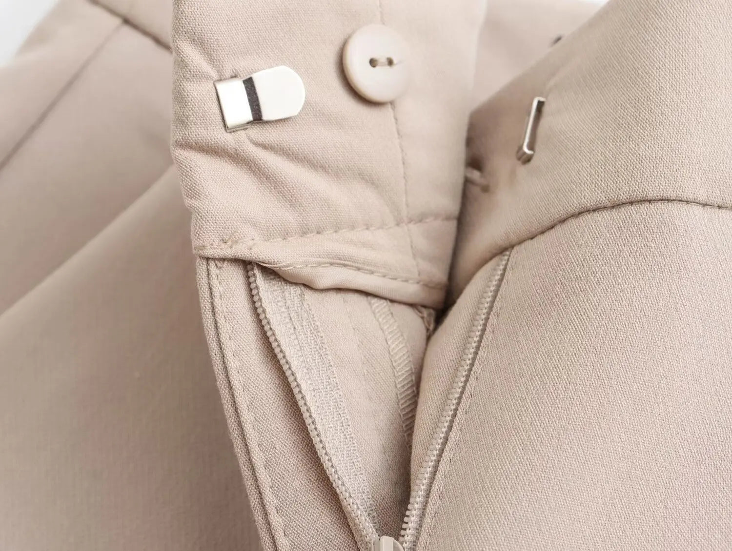 Close-up of khaki women's suit set with detailed stitching and secure fastenings