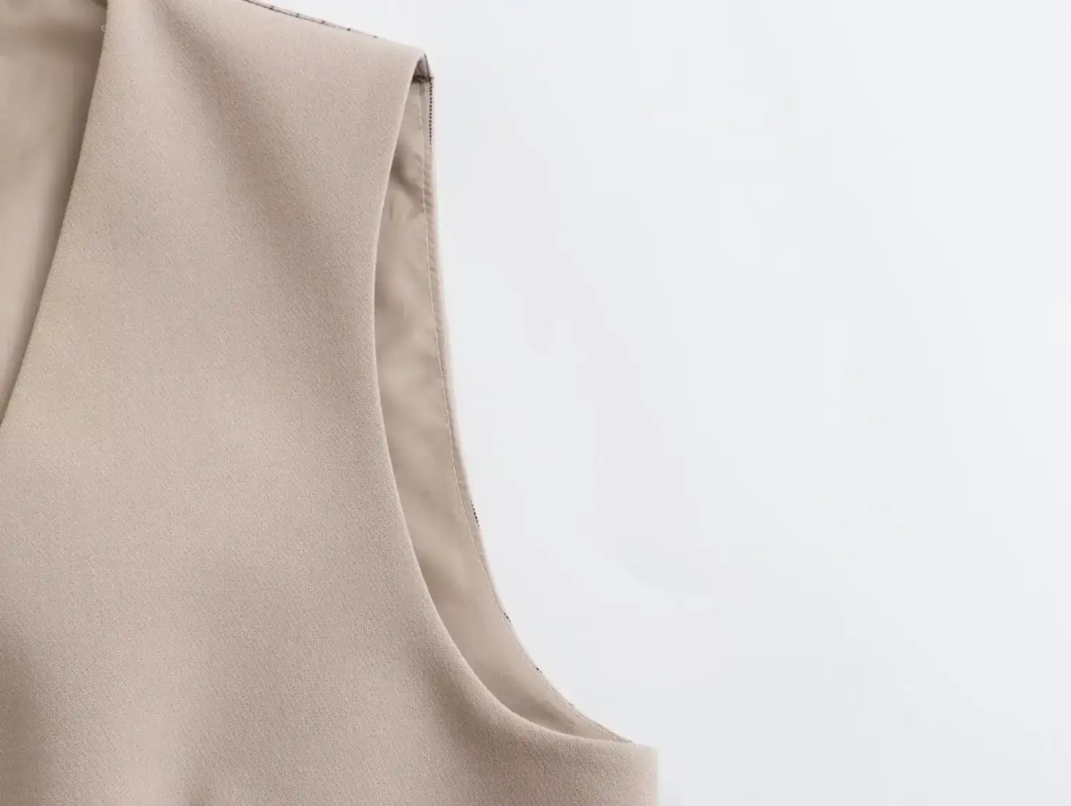 Close-up of a khaki women's suit set featuring a sleeveless top with a smooth finish