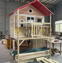Wooden kids playhouse on stilts with red roof, porch railing, and teal slide