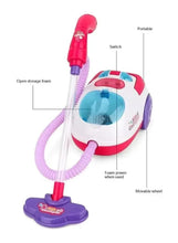 Pink and white portable toy vacuum with pink hose, wheels and stand base