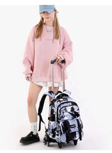 Kids rolling backpack with black and white splatter print, front view with extended handle