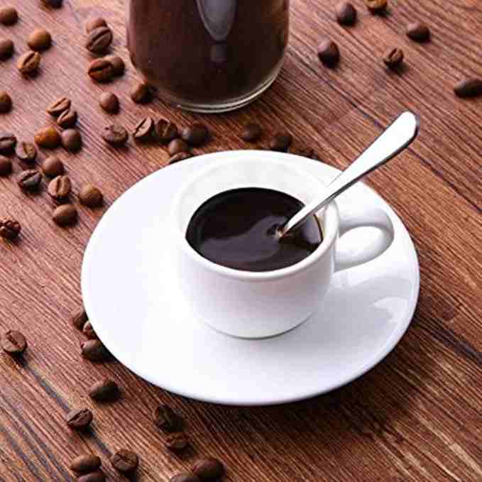 Silver stainless steel dinner spoons set with coffee cup and saucer on wooden table