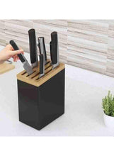 Knife rack with black block, wooden top, and stainless steel knives during loading