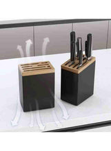 Knife rack with black block, wooden top, and stainless steel knife holders