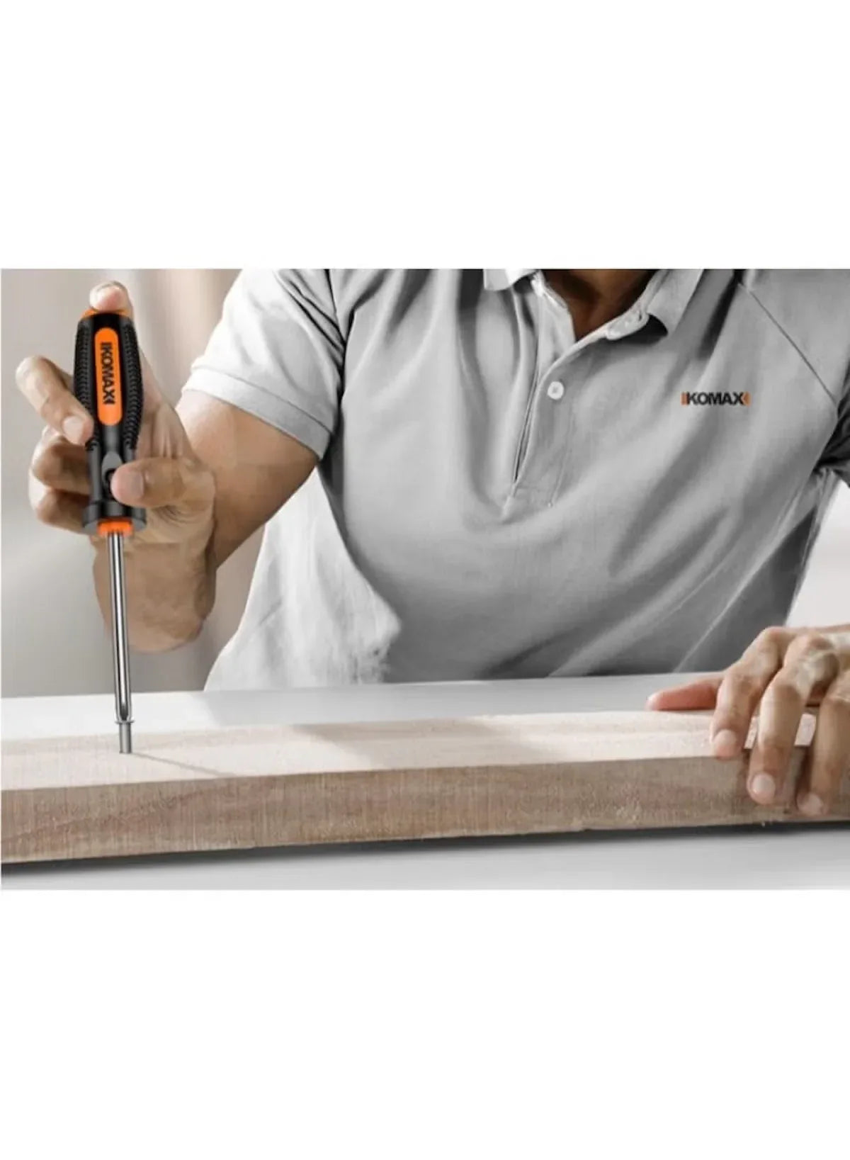 Orange-handled screwdriver tightening screws into a wooden board