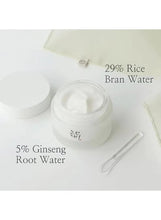 Open white cream jar with visible cream inside and a small spatula