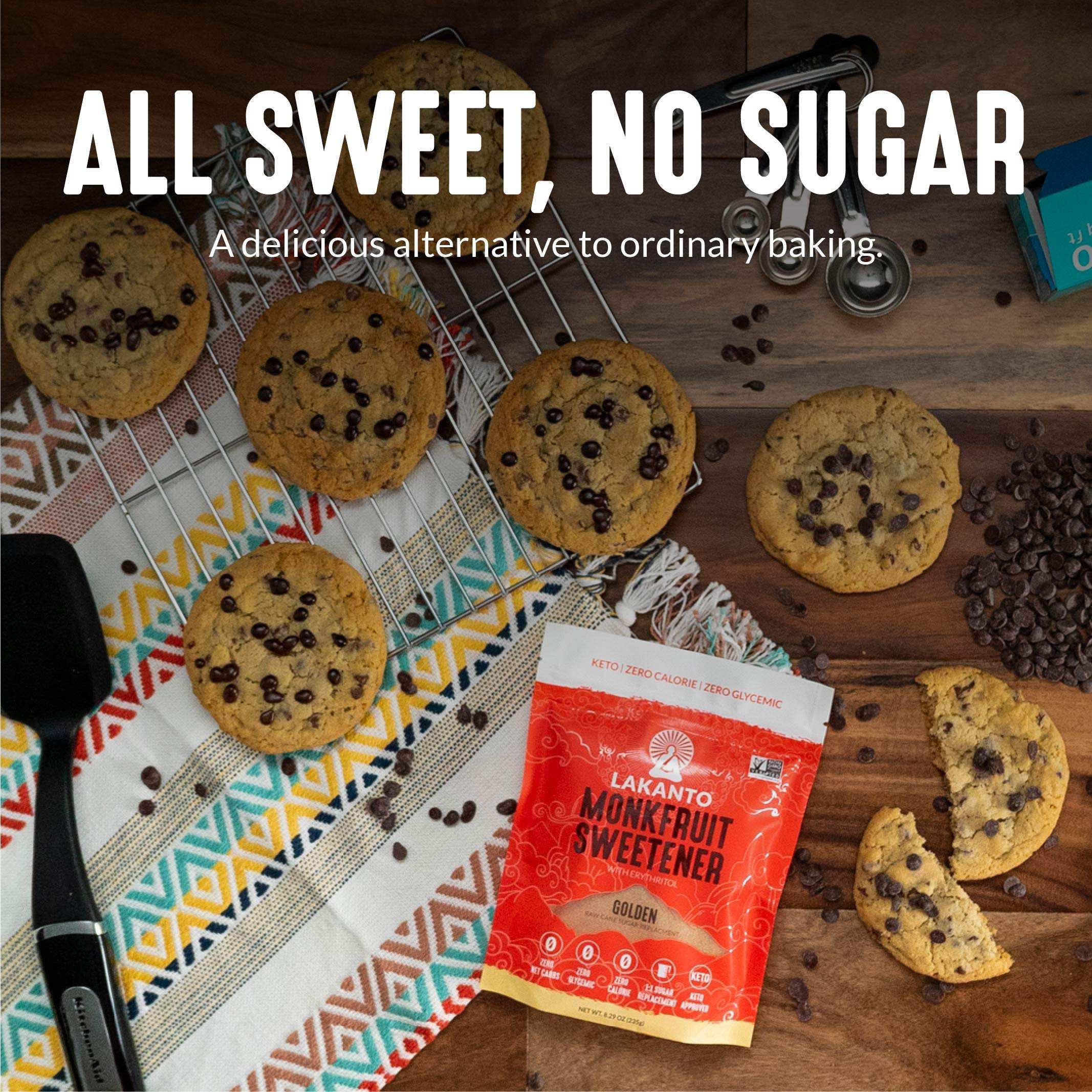 Lakanto sugar replacement golden monkfruit sweetener pouch on wooden table surrounded by chocolate chip cookies and baking tools