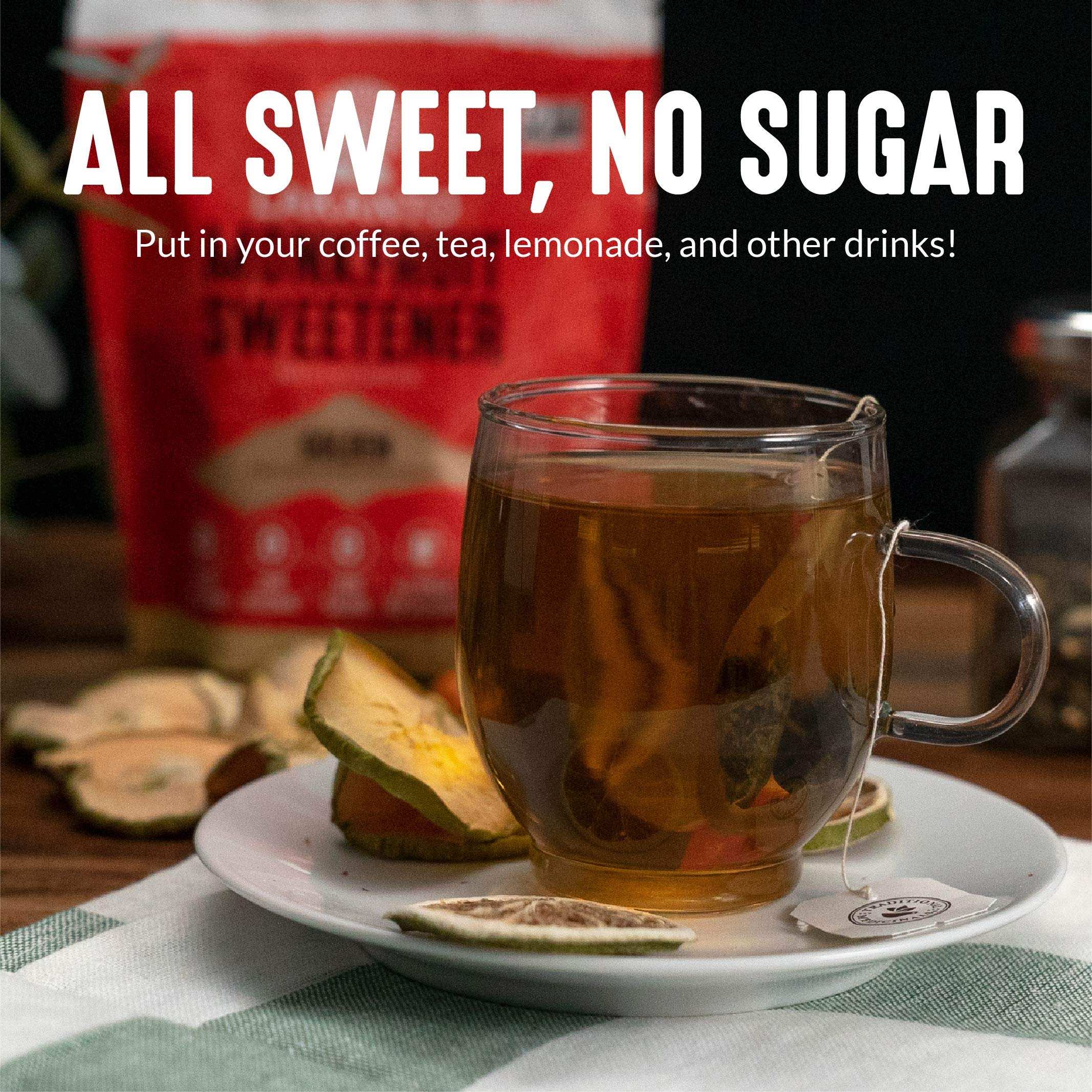 Clear glass cup of tea with dried citrus and Lakanto sugar replacement pouch blurred behind