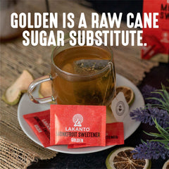 Red Lakanto monkfruit sweetener packets Golden on saucer next to a cup of tea with dried citrus