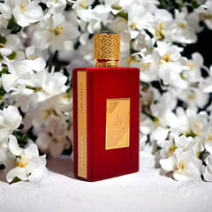 Lattafa Asdaaf Ameerat Al Arab perfume 100ml in a red and gold bottle surrounded by white flowers
